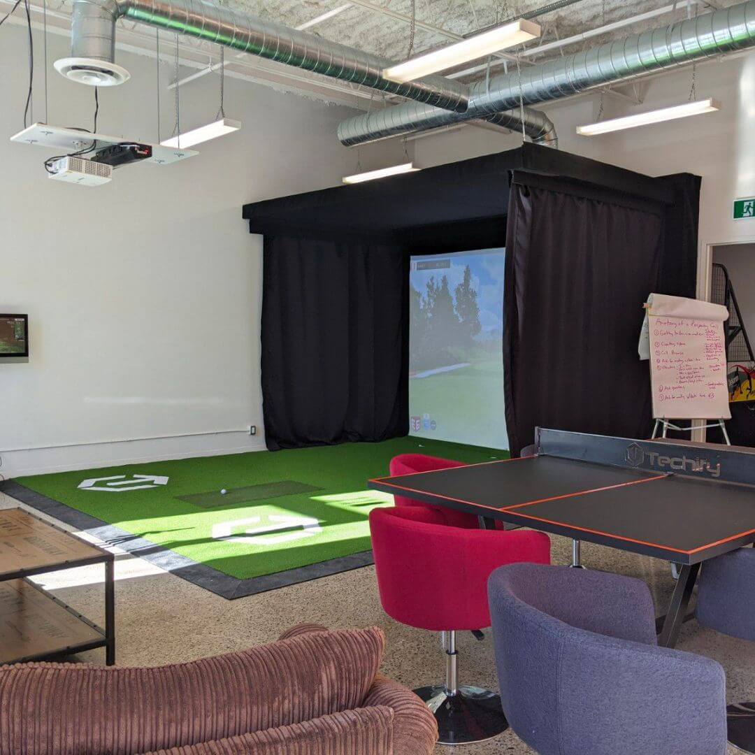 Commercial golf simulator setup in a corporate office breakroom
